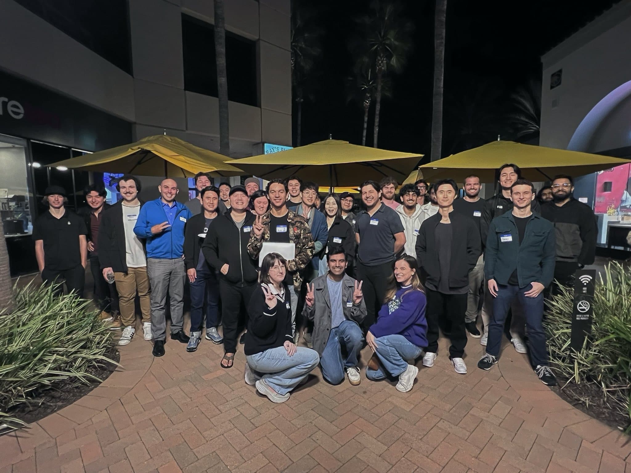 A tech night group photo on the patio after dark